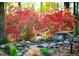 Backyard landscaped with a scenic waterfall feature surrounded by vibrant azaleas creating a relaxing outdoor ambiance at 1039 Smyrna Rd Sw, Conyers, GA 30094