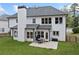 An expansive two-story white home, showcasing a cozy patio and lush green backyard at 13070 Tidewater Xing, Alpharetta, GA 30005