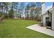 A spacious backyard featuring a well-maintained lawn, mature trees, and a cozy patio area at 13070 Tidewater Xing, Alpharetta, GA 30005