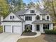 Elegant two-story home boasts a classic white facade, black accents, and a spacious two-car garage at 13070 Tidewater Xing, Alpharetta, GA 30005