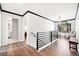 Hallway featuring a modern railing, light fixture, hardwood floors and a window with a view at 13070 Tidewater Xing, Alpharetta, GA 30005