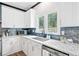 White cabinets and stainless steel appliances, granite countertops, sink and a kitchen window overlooking nature at 13070 Tidewater Xing, Alpharetta, GA 30005