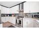 Bright kitchen features white cabinetry, stainless steel appliances, and stone backsplash at 13070 Tidewater Xing, Alpharetta, GA 30005