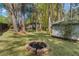Private backyard featuring a stone fire pit, mature trees, and a detached shed for storage at 2123 Juanita St, Decatur, GA 30032