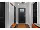 Bright foyer with brick accent wall, coat closet, new light fixture, and hardwood floors at 2123 Juanita St, Decatur, GA 30032