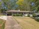 Charming one-story home with a covered parking area, manicured bushes and a welcoming front porch at 2123 Juanita St, Decatur, GA 30032