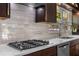 Close-up of a kitchen featuring a gas stovetop, white countertops, and a stylish backsplash with a view out the window at 2123 Juanita St, Decatur, GA 30032