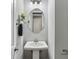 Elegant powder room showcasing a pedestal sink, decorative mirror, and minimalist design at 26 Hardpan Aly, Marietta, GA 30066