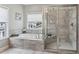 Relaxing bathroom featuring a soaking tub, separate glass-enclosed shower, and neutral-toned tile at 26 Hardpan Aly, Marietta, GA 30066