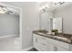 Bathroom featuring double vanity, granite countertops, and modern lighting, with a bedroom in the background at 26 Hardpan Aly, Marietta, GA 30066