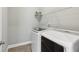 Bright laundry room featuring a modern, white front-loading washer and dryer set with a shelf for storage at 26 Hardpan Aly, Marietta, GA 30066