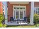 Inviting patio with brick exterior, white columns, comfortable seating, and lush landscaping for relaxing outdoors at 1029 Piedmont Ne Ave # 102, Atlanta, GA 30309