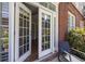 Charming outdoor patio with French doors, brick exterior, comfortable seating, and lush greenery at 1029 Piedmont Ne Ave # 102, Atlanta, GA 30309