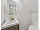 Stylish powder room features a modern vanity with a gold faucet and a round mirror at 1282 Eastridge Sw Rd, Atlanta, GA 30311