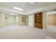 Open basement showcasing neutral carpeting, wood shelving, and a doorway to another room at 3925 Waterford Dr, Suwanee, GA 30024