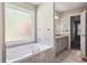 Bathroom with a large soaking tub, tiled floors and a separate vanity area at 3925 Waterford Dr, Suwanee, GA 30024