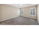Spacious primary bedroom with a tray ceiling, carpet flooring, and natural light at 3925 Waterford Dr, Suwanee, GA 30024