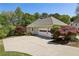 Spacious home garage with a large driveway, an American flag, and mature landscaping at 3925 Waterford Dr, Suwanee, GA 30024