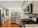 Well-lit kitchen featuring stainless steel appliances, granite countertops, and wood flooring at 3925 Waterford Dr, Suwanee, GA 30024