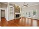 Bright living room with stone fireplace, hardwood floors, built-in shelves, and french doors to the outside at 3925 Waterford Dr, Suwanee, GA 30024