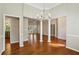 Open-concept living room featuring hardwood floors, decorative columns and chandeliers with a view to the kitchen at 3925 Waterford Dr, Suwanee, GA 30024