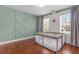 Bedroom with decorative accent wall, hardwood floors, and natural light at 4013 Suwanee Place Dr, Suwanee, GA 30024