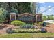 Stone entrance to Suwanee Place features manicured flowerbeds and lush greenery for a welcoming first impression at 4013 Suwanee Place Dr, Suwanee, GA 30024