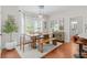 Bright dining area with modern light fixture, wooden table and seating, and views into the kitchen at 4013 Suwanee Place Dr, Suwanee, GA 30024