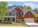 Charming two-story home with brick and gray siding, manicured lawn, and a welcoming front porch at 4013 Suwanee Place Dr, Suwanee, GA 30024