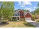 Attractive two-story home with brick and siding, a lush green lawn, and a welcoming covered porch at 4013 Suwanee Place Dr, Suwanee, GA 30024