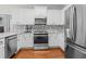 Well-equipped kitchen with stainless steel appliances, white cabinets, and stylish backsplash at 4013 Suwanee Place Dr, Suwanee, GA 30024