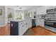 Modern kitchen with stainless steel appliances, stylish backsplash, two-tone cabinets, and breakfast bar at 4013 Suwanee Place Dr, Suwanee, GA 30024
