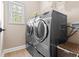 Laundry room with washer and dryer, tile floors, and shelving at 4013 Suwanee Place Dr, Suwanee, GA 30024