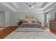 Main bedroom featuring hardwood floors, tray ceilings, and a large area rug at 4013 Suwanee Place Dr, Suwanee, GA 30024