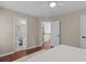 A beautifully staged bedroom with hardwood floors, neutral walls and a view to the bathroom at 4013 Suwanee Place Dr, Suwanee, GA 30024