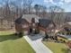 Aerial view of the brick home with a well-manicured lawn and a long driveway at 4538 Sterling Pointe Nw Dr, Kennesaw, GA 30152