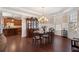 Formal dining room boasts an elegant chandelier, wainscoting, and hardwood floors at 4538 Sterling Pointe Nw Dr, Kennesaw, GA 30152
