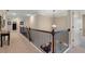 Upstairs hallway with carpet, decorative railing, and a stylish pendant light adding to the home's charm at 4538 Sterling Pointe Nw Dr, Kennesaw, GA 30152