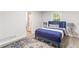 Bedroom with a large window, blue rug, and blue upholstered bed frame with a white comforter at 1340 Hawthorne Se Ave, Smyrna, GA 30080