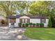 Charming white brick home with a well-manicured lawn and lovely landscaping at 1340 Hawthorne Se Ave, Smyrna, GA 30080