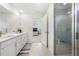 Modern bathroom featuring double sinks, quartz counters, tiled floor and a glass-enclosed shower at 2770 Westgate Park Dr, Loganville, GA 30052