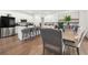 Open-concept kitchen and dining area with stainless steel appliances, white cabinetry and wood floors at 2770 Westgate Park Dr, Loganville, GA 30052