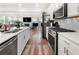 Bright open-concept kitchen with stainless appliances, white cabinetry, and a view into the living room at 2770 Westgate Park Dr, Loganville, GA 30052