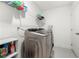 Modern laundry room with stainless steel washer and dryer, shelving, and white walls at 2770 Westgate Park Dr, Loganville, GA 30052