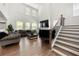 Bright living room with large windows, high ceilings, a fireplace, and a staircase at 2770 Westgate Park Dr, Loganville, GA 30052