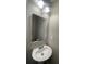 A close-up view of a bathroom sink with a modern rounded mirror and updated lighting at 3870 Spring Moss Cir, Snellville, GA 30039
