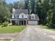 Beautiful two-story home featuring a two-car garage, a well-maintained lawn, and lots of trees at 3870 Spring Moss Cir, Snellville, GA 30039