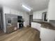 Modern kitchen with stainless steel appliances, laminate floors, white cabinets, and granite counters at 3870 Spring Moss Cir, Snellville, GA 30039