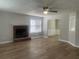 Spacious living room with laminate flooring, a cozy fireplace, and a glimpse into the dining area at 3870 Spring Moss Cir, Snellville, GA 30039