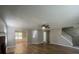 Open-concept living room with laminate floors, a ceiling fan, and staircase access to upper level at 3870 Spring Moss Cir, Snellville, GA 30039